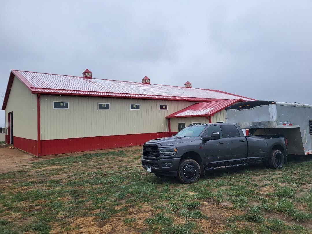 A truck is parked in front of a building with a trailer attached to it.
