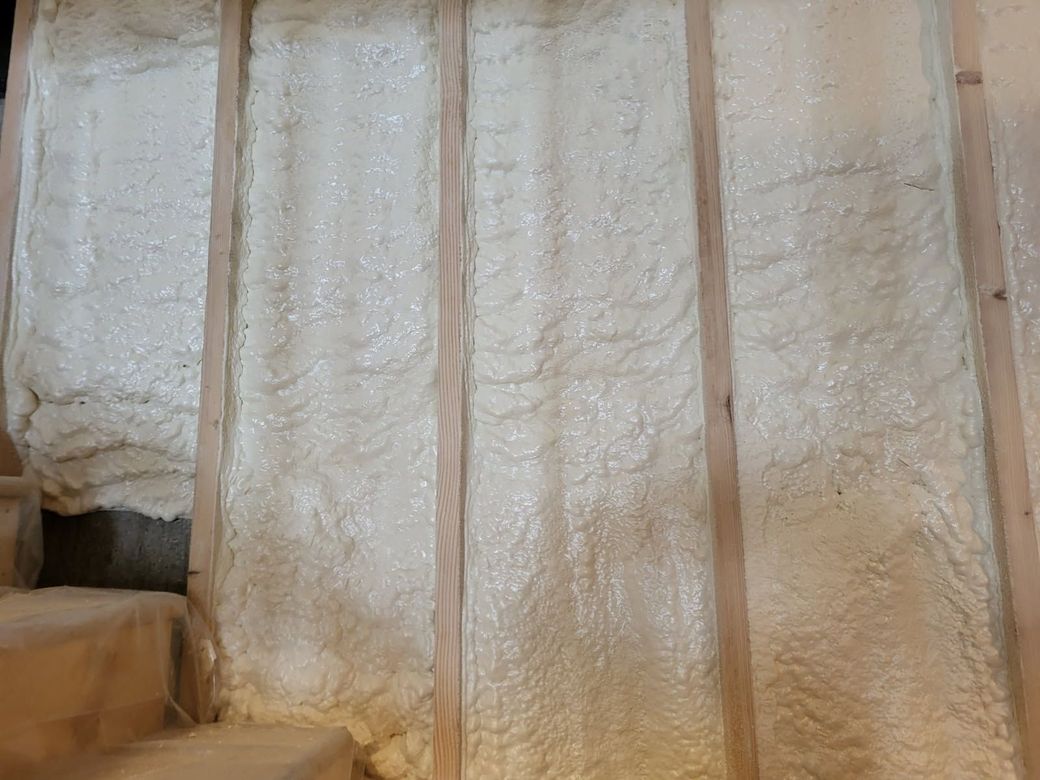 A wall with a lot of foam on it and wooden beams.