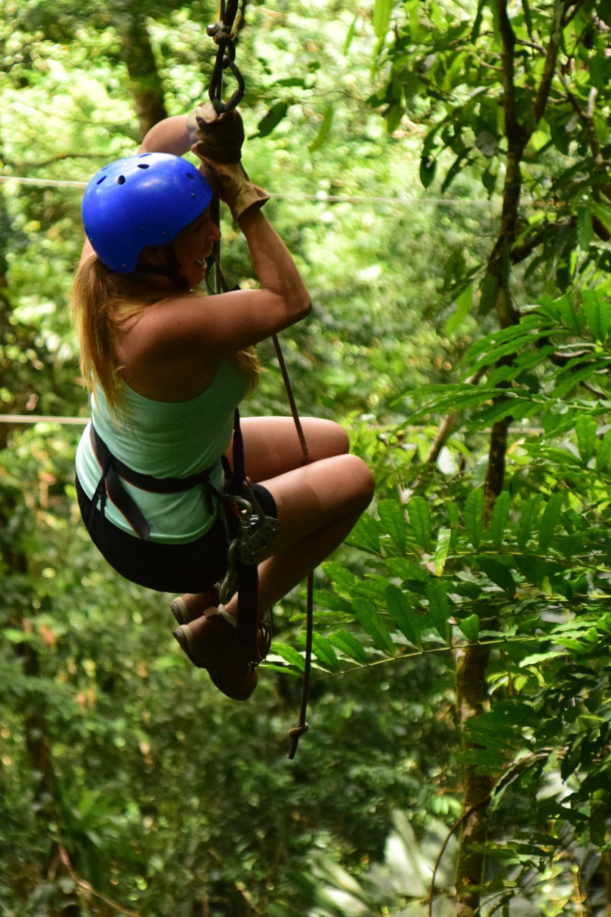 woman on zip line in trees