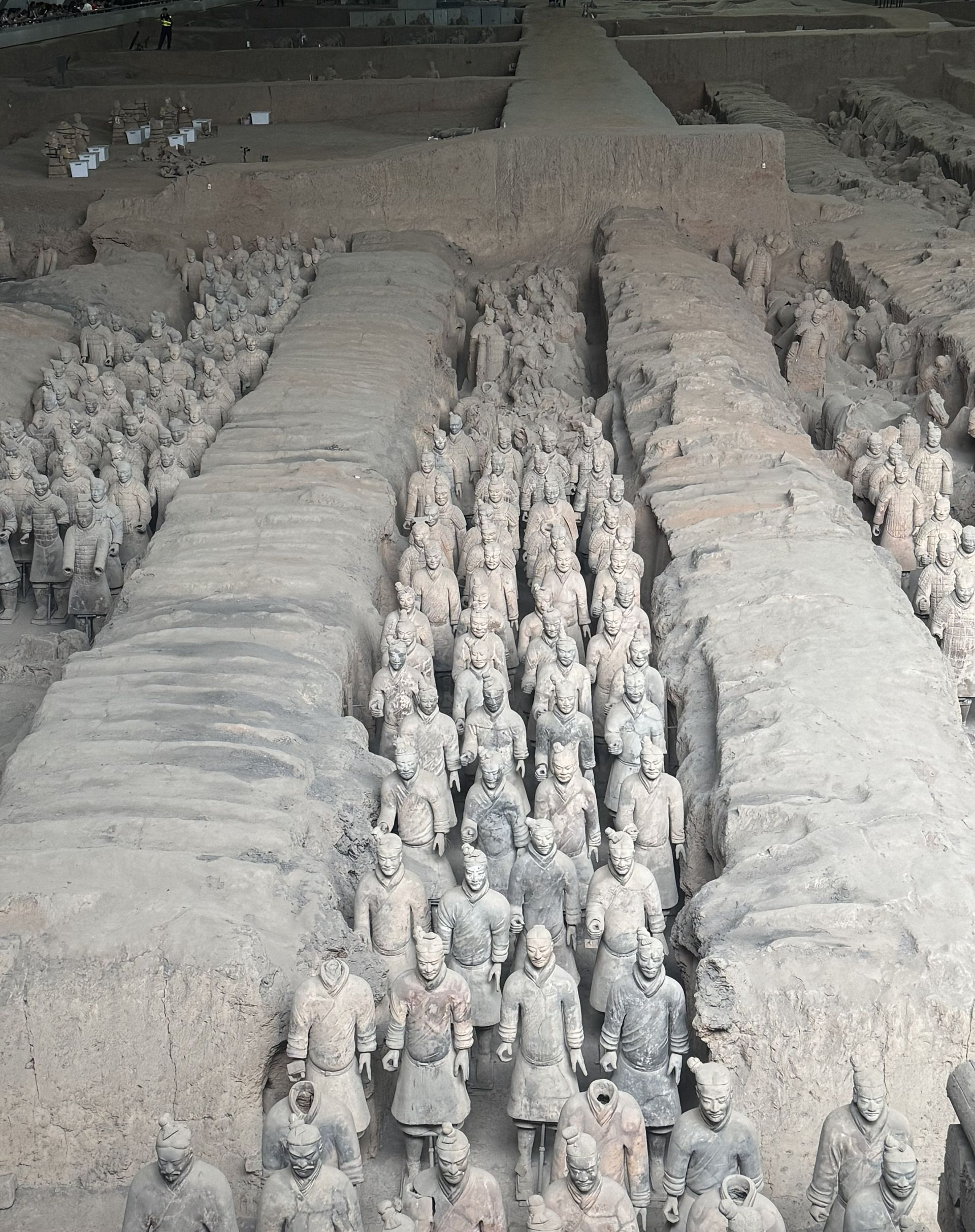 Terracotta Army soldiers in formation, excavated in trenches. Beige and gray colors, ancient China.