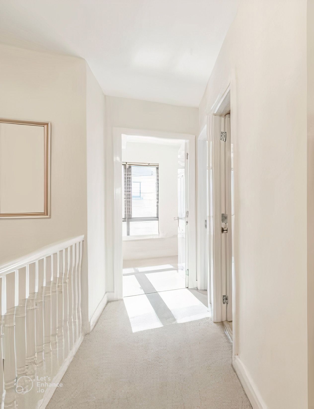 A bright hallway with cream-colored walls, light carpet, and doorways leading to rooms and a window.