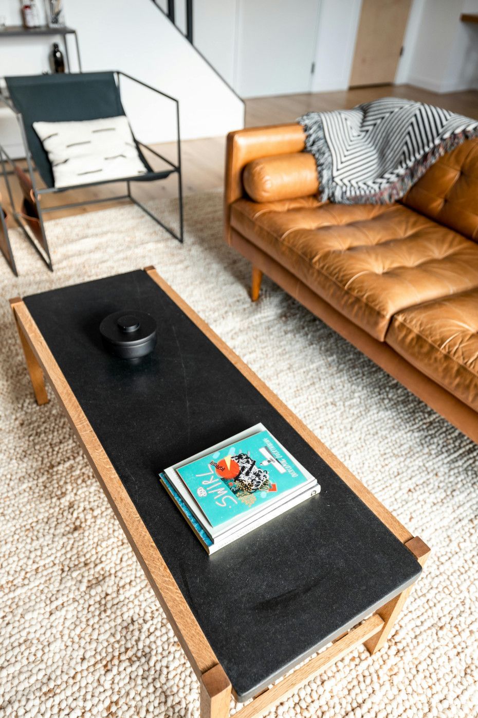 A living room with a brown leather couch and a black coffee table
