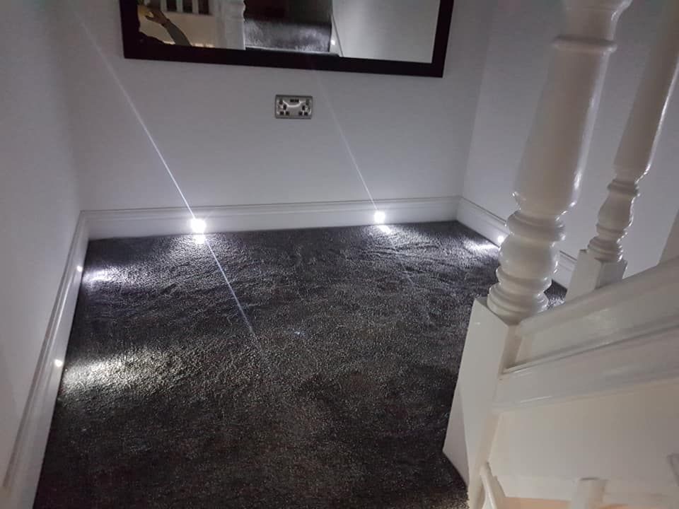 Stairway landing with gray carpet, white walls, and built-in lights; staircase on the right.