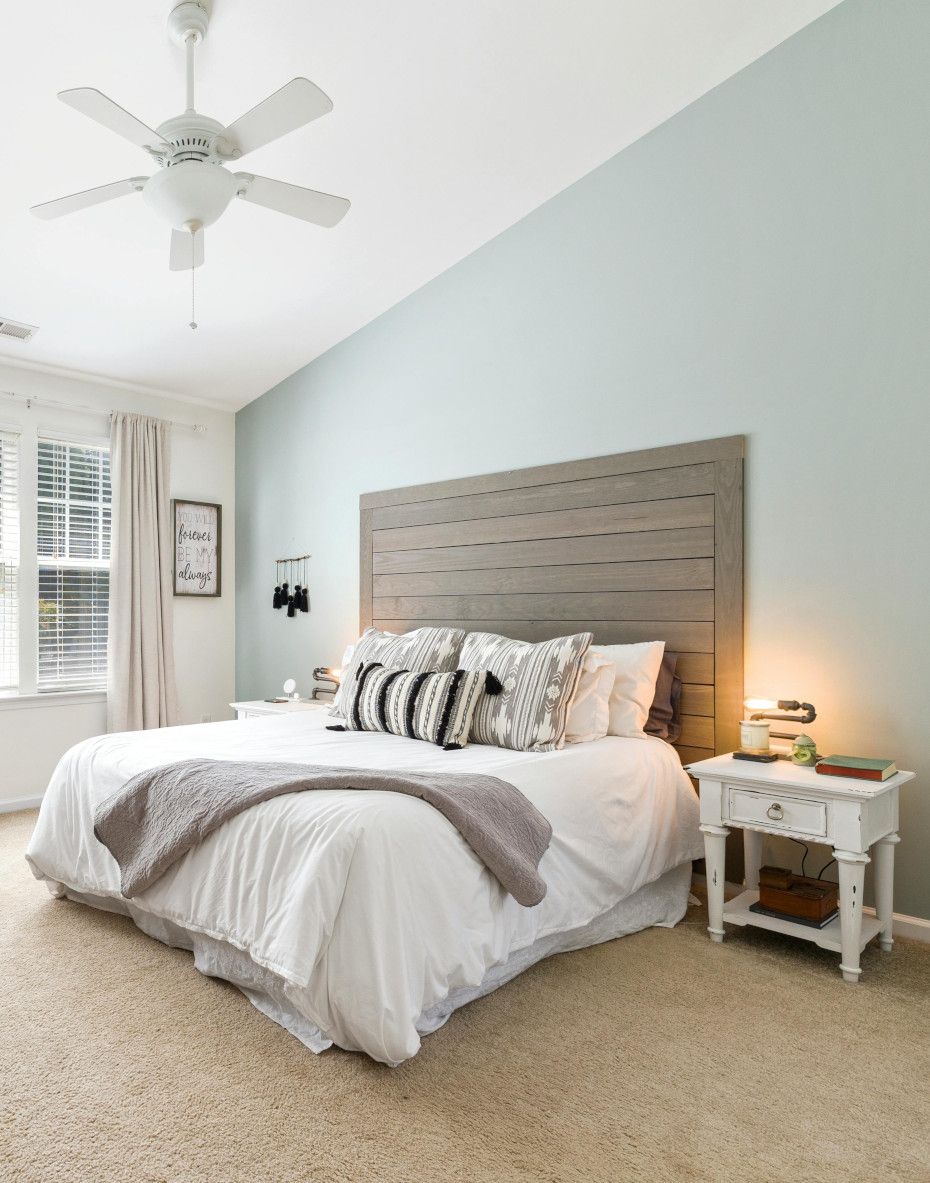 A bedroom with a bed , nightstands , and a ceiling fan.