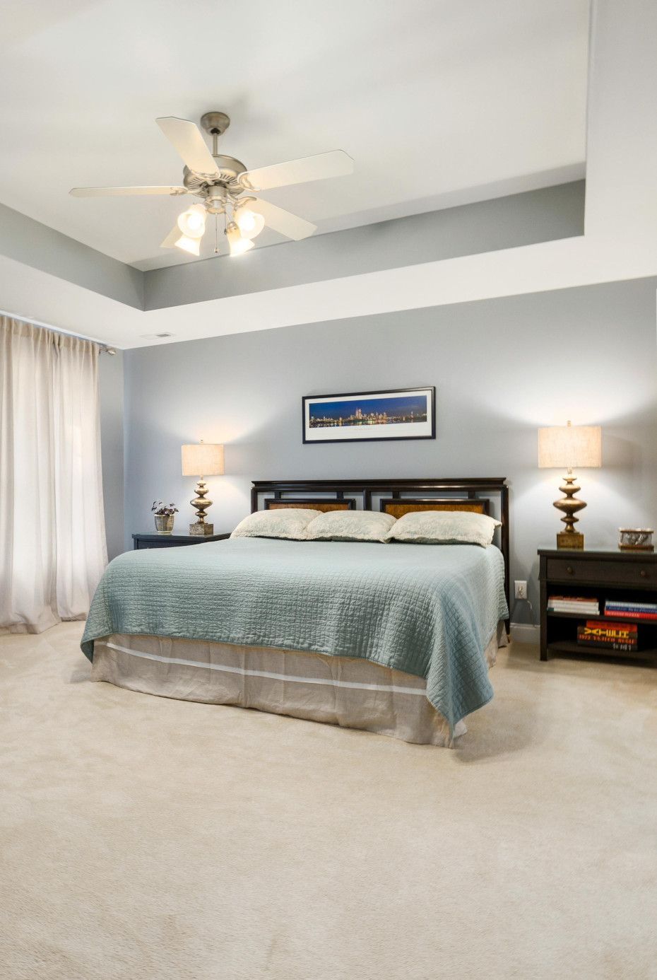A bedroom with a king size bed and a ceiling fan.