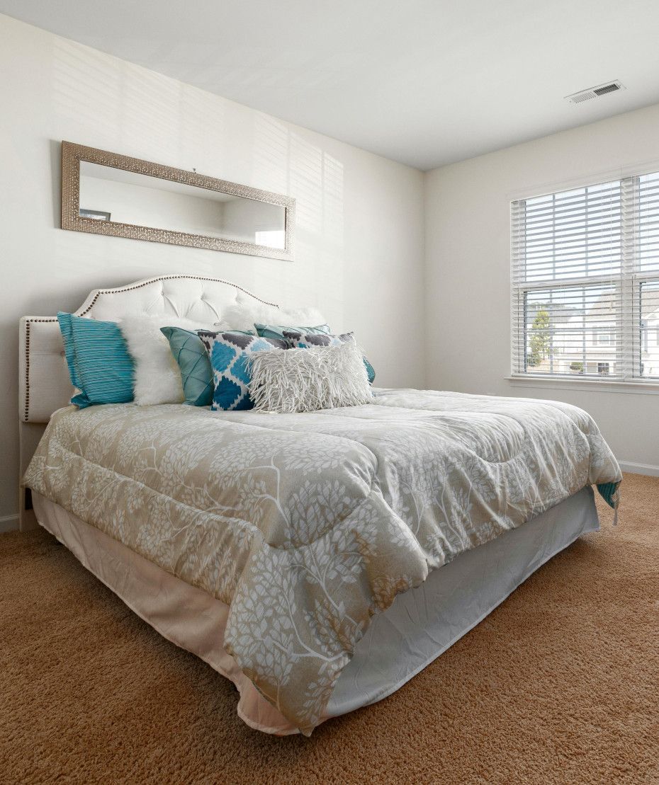 A bedroom with a large bed and a window.