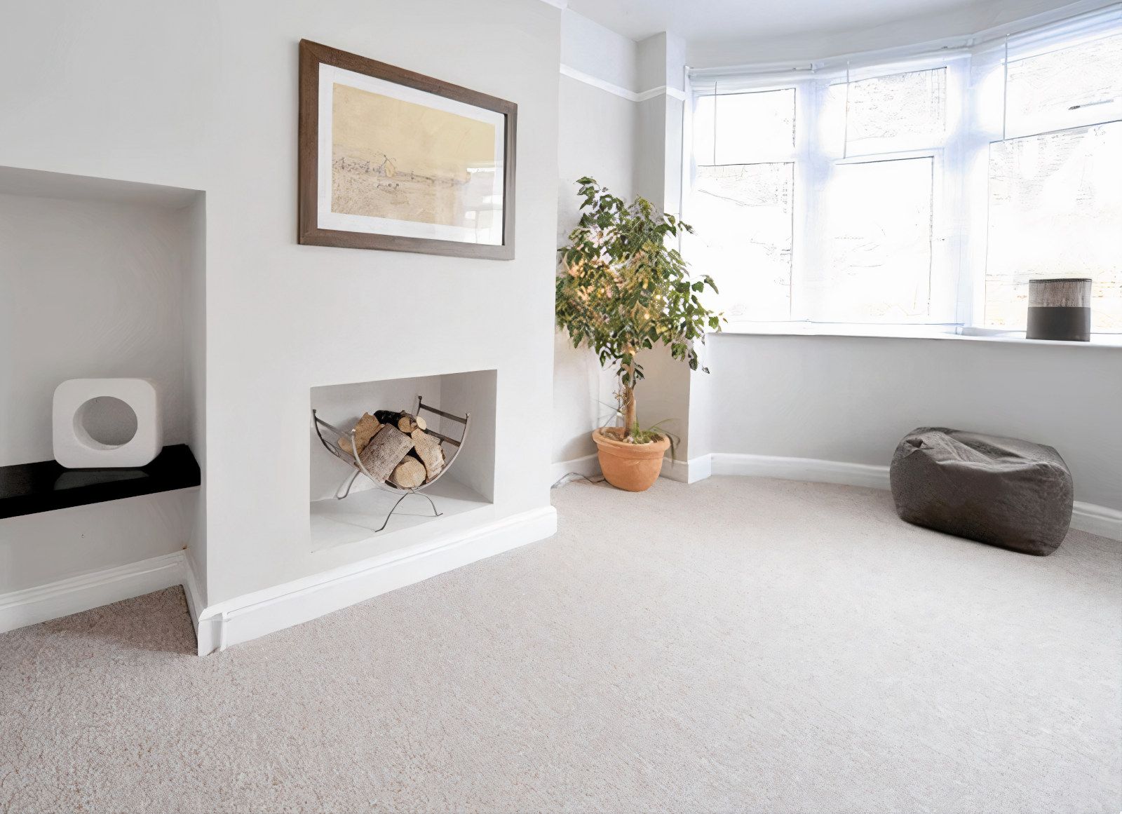 Light-filled living room with built-in fireplace, framed art, potted plant, and a beanbag chair.