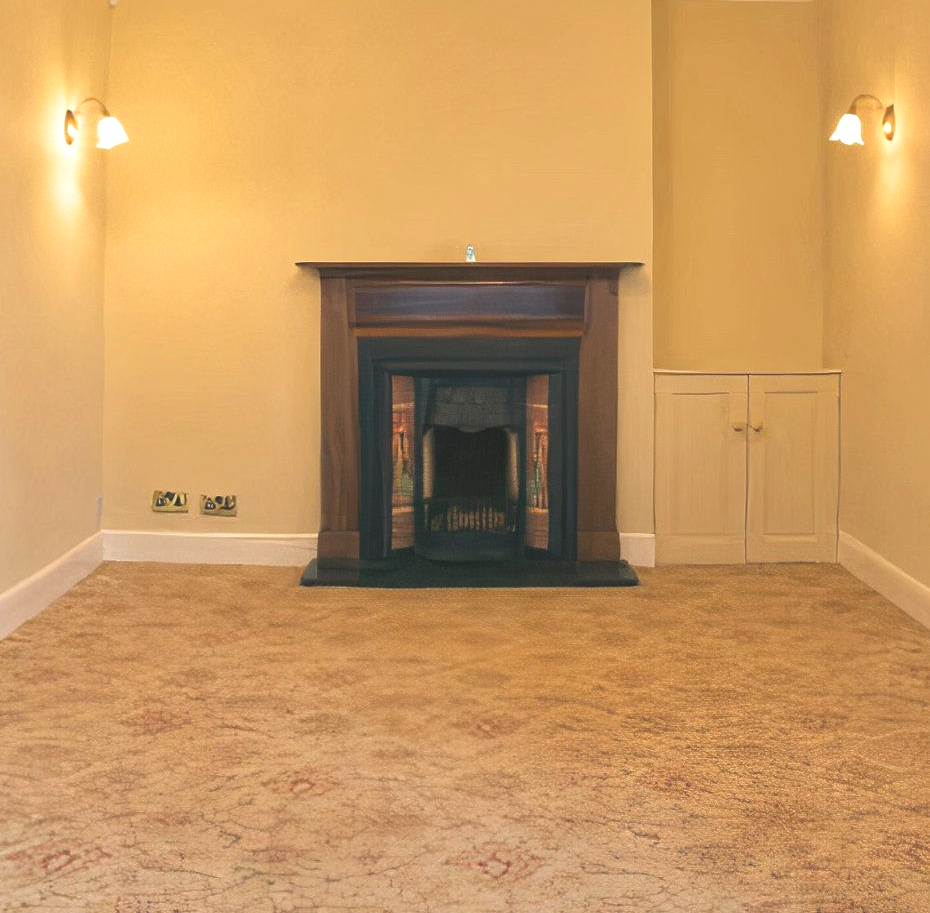 Empty room with a fireplace, cabinets, and sconce lighting. The room has beige walls and carpet.