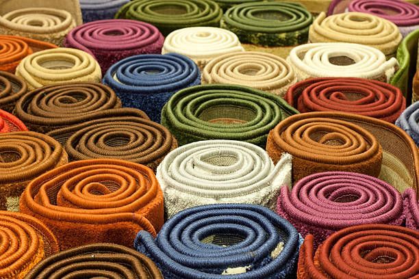 Rolls of colorful carpet stacked together.