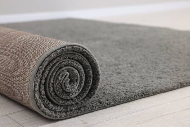 Rolled grey carpet on floor in room, closeup