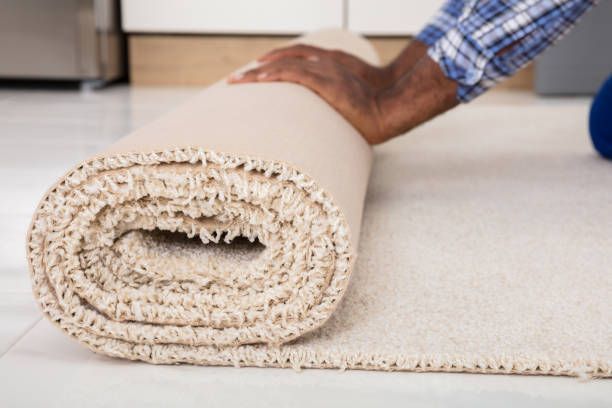 Worker's hands rolling carpet at home
