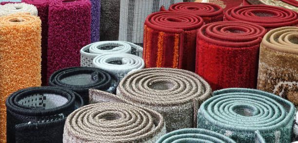 Rolled-up carpets in various colors: red, tan, pink, gray, and teal.