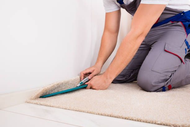 Craftsman fitting carpet on floor with cutter