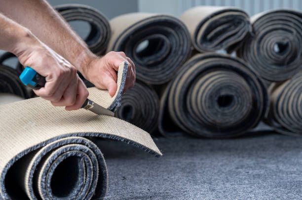 Handyman cutting a new carpet with a carpet cutter