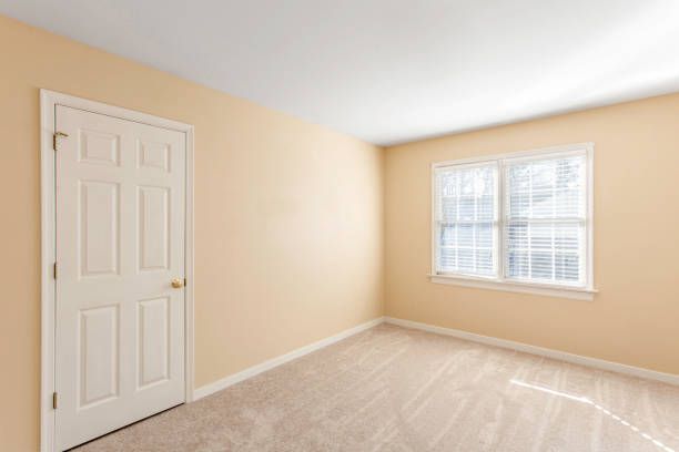 A spacious empty bedroom painted in calming beige tones
