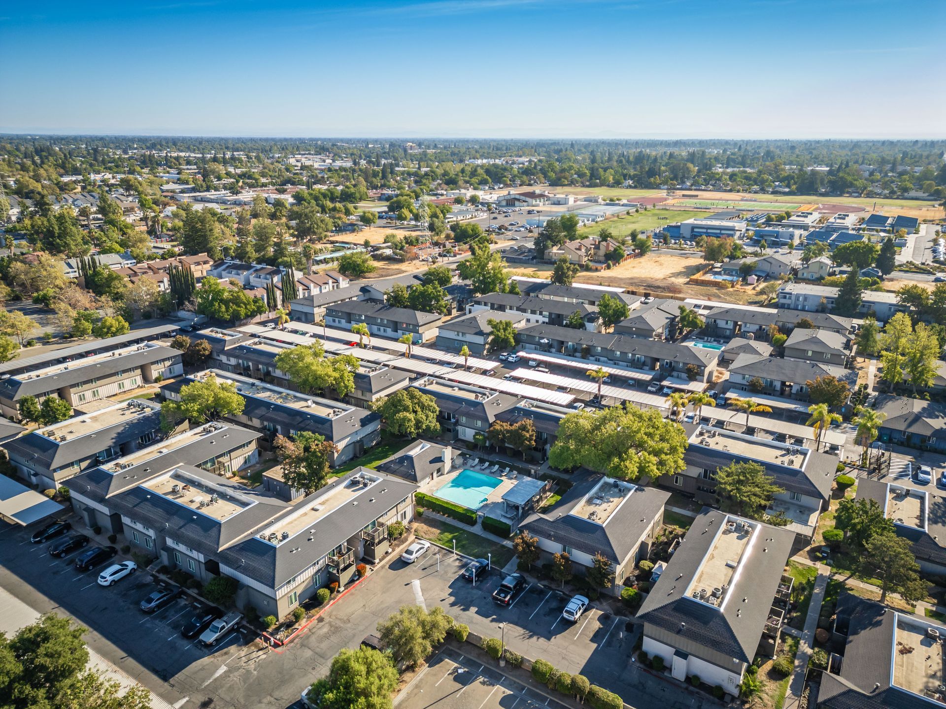 An aerial view of a residential area with a pool in the middle of it.