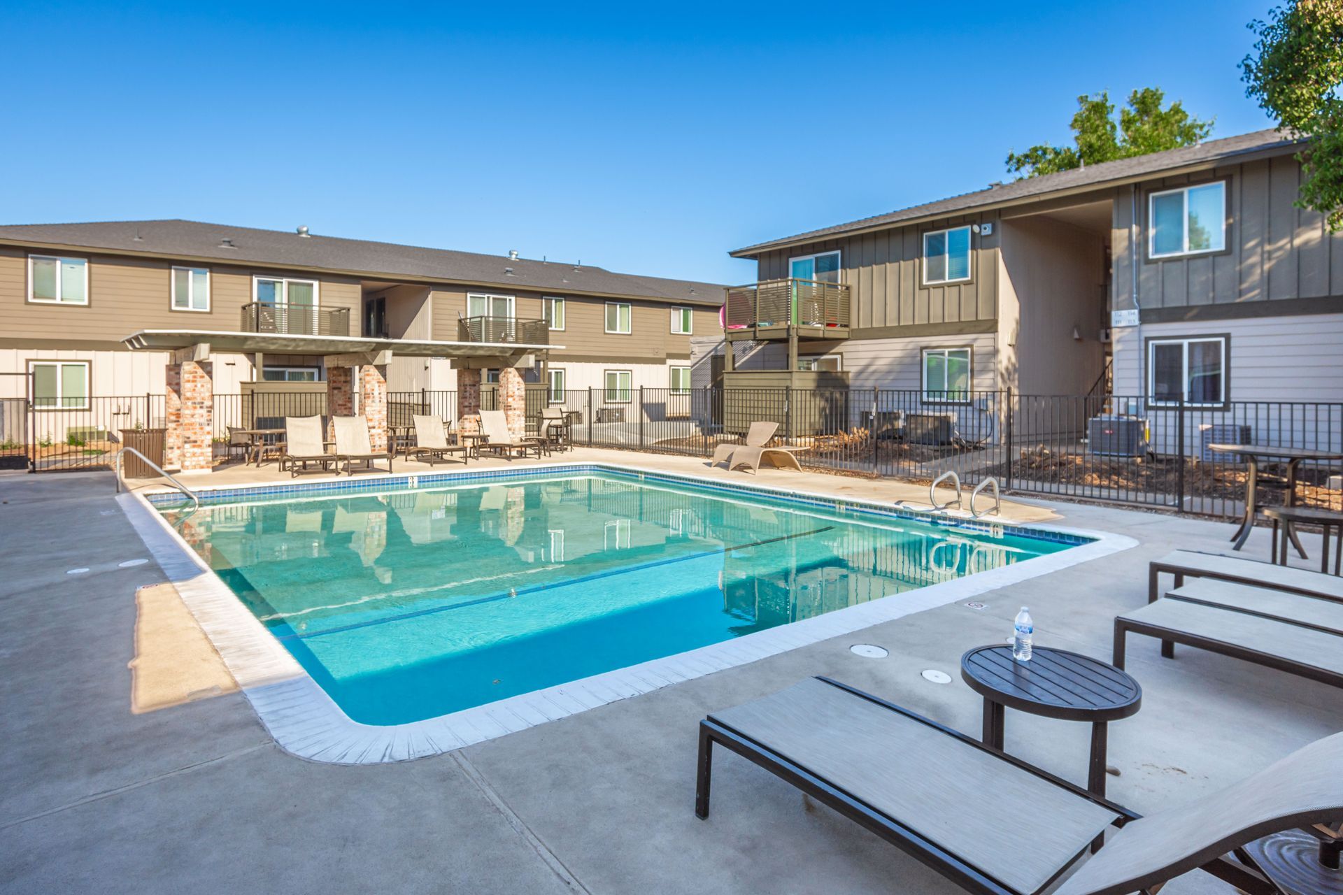 There is a large swimming pool in front of a building.