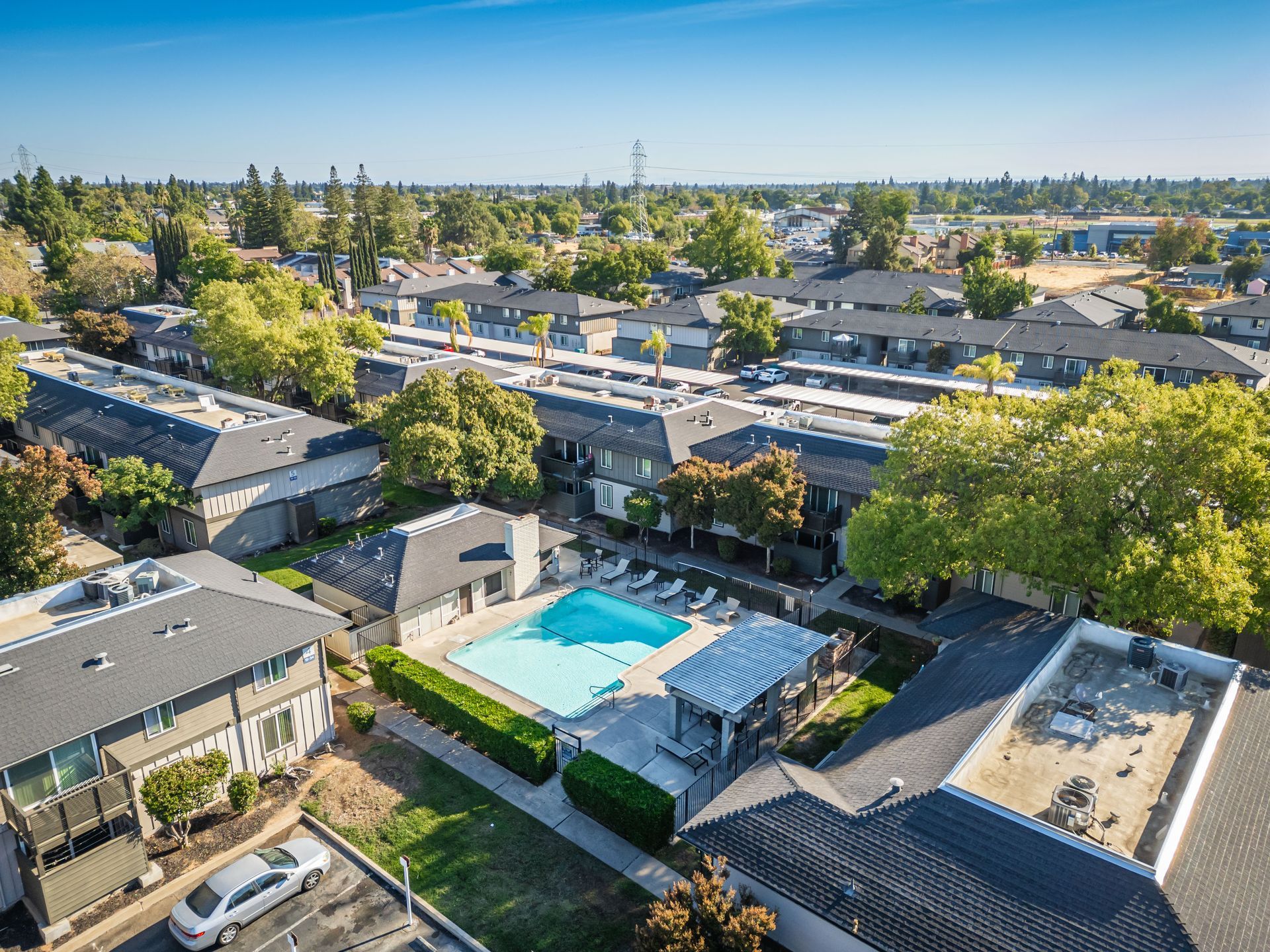 An aerial view of a residential area with a swimming pool surrounded by buildings.