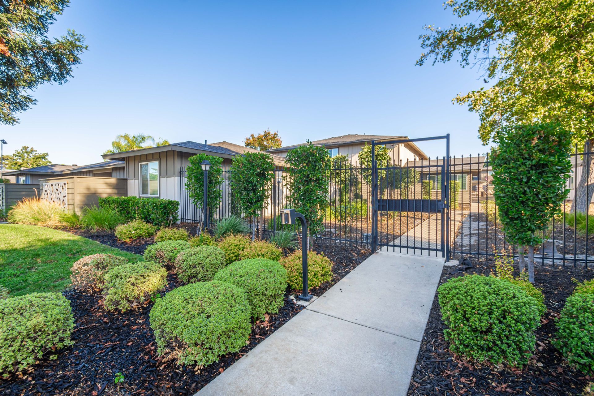 A house with a fence and a walkway leading to it