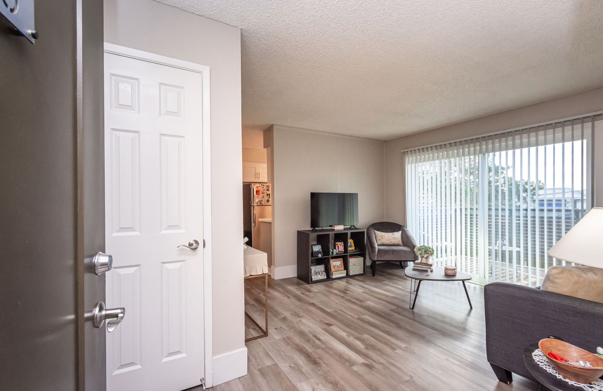 A living room with a couch , chair , table and television.