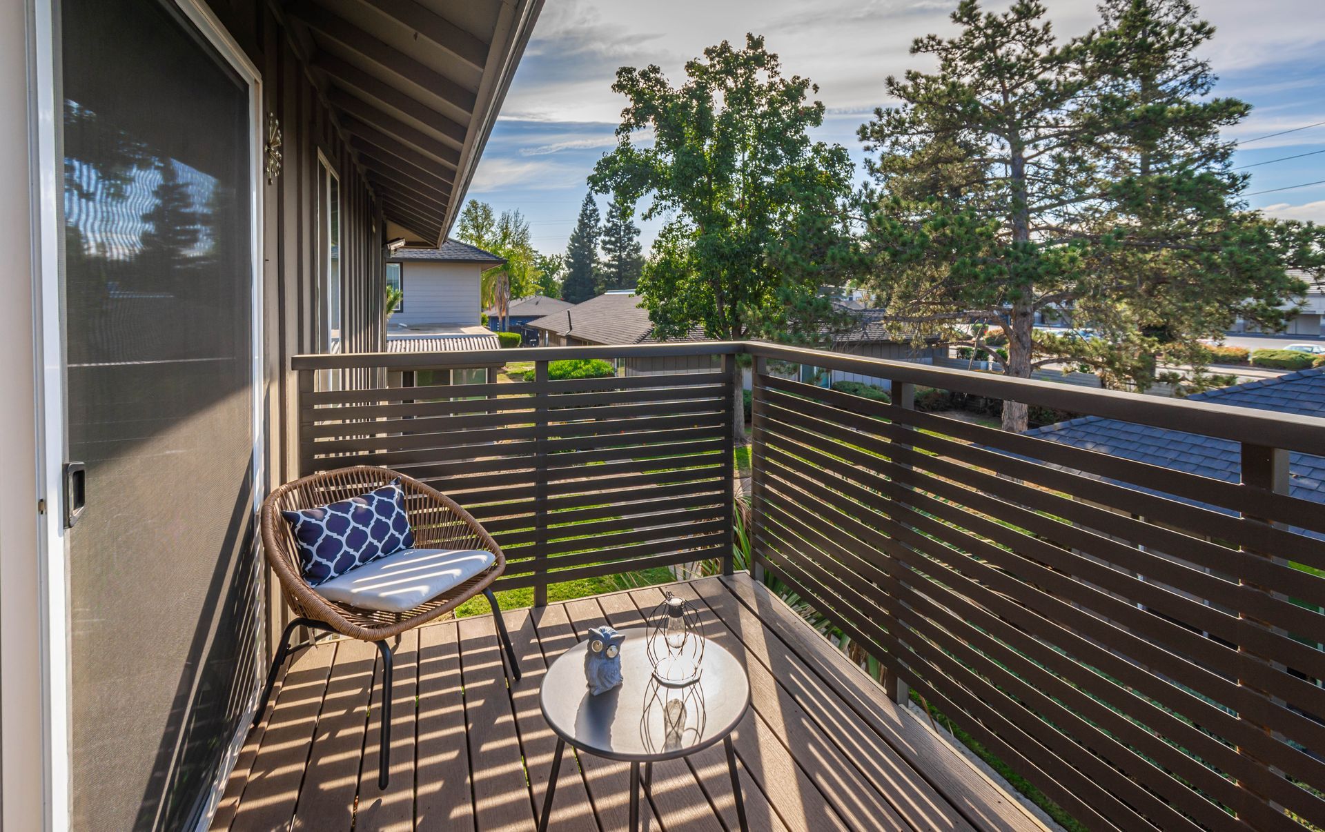There is a balcony with a chair and a table on it.