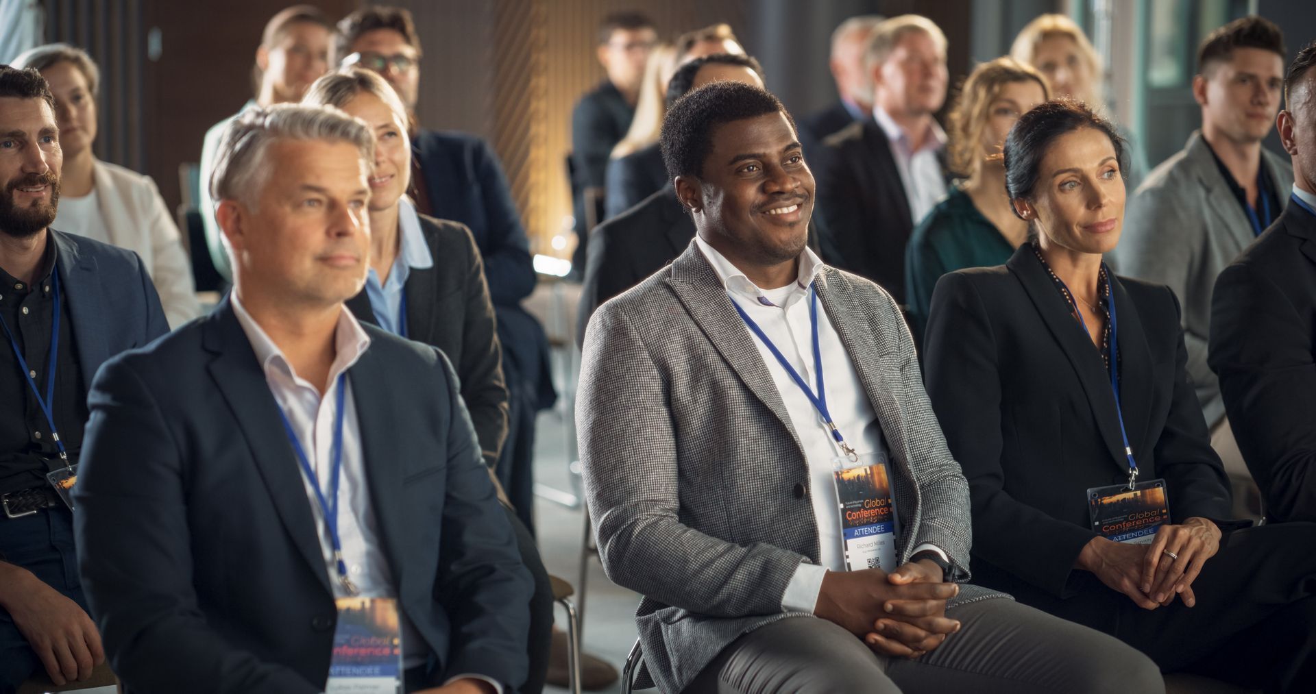 A group of people are sitting in a row at a conference.