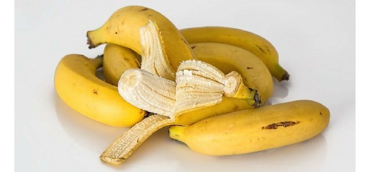 Conjunto de bananos con uno medio pelado