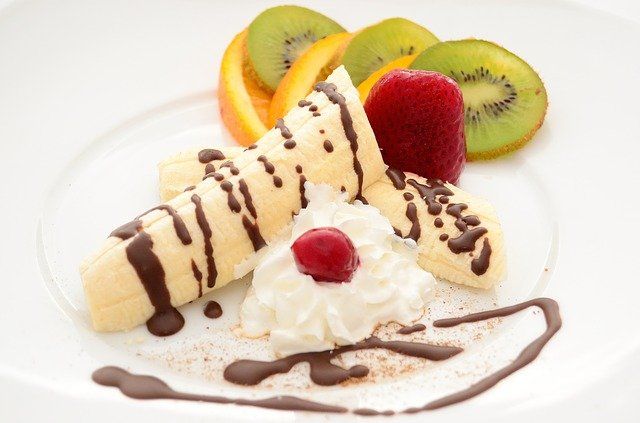 Plato de postre con banano, kiwi, fresas y naranja