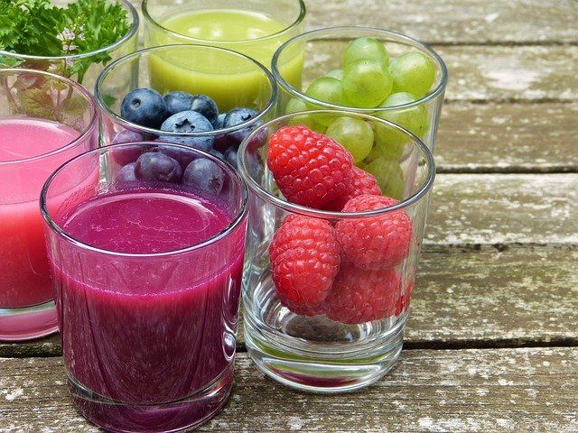 Vasos de vidrio con jugos y frutas
