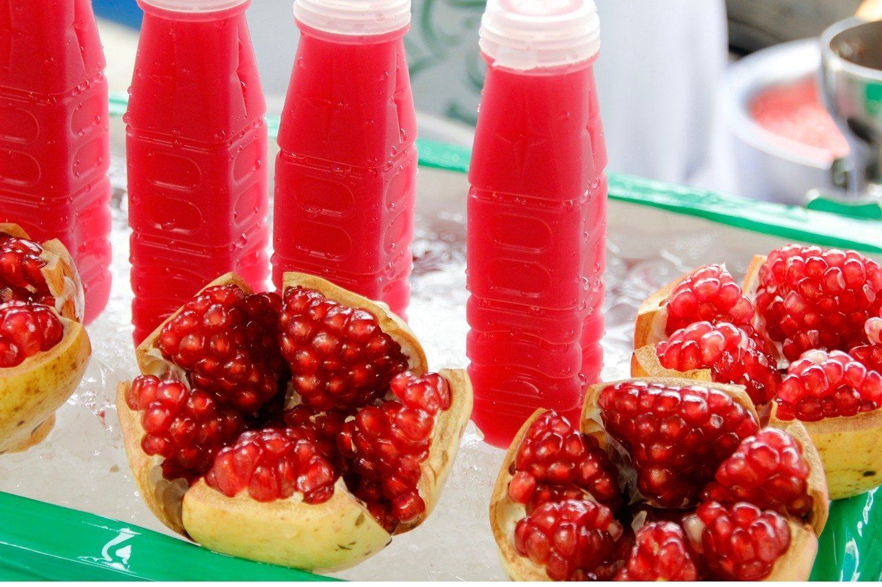 Frutas abiertas delante de botellas de jugo