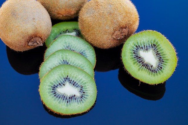 Acercamiento a unos kiwis, con uno en rodajas