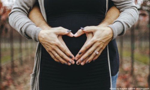 Vista de estómago de mujer con manos abrazadas