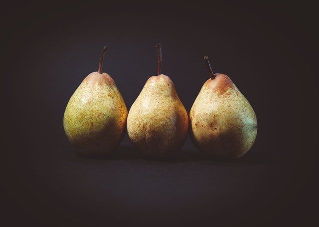 3 peras enteras en fondo oscuro