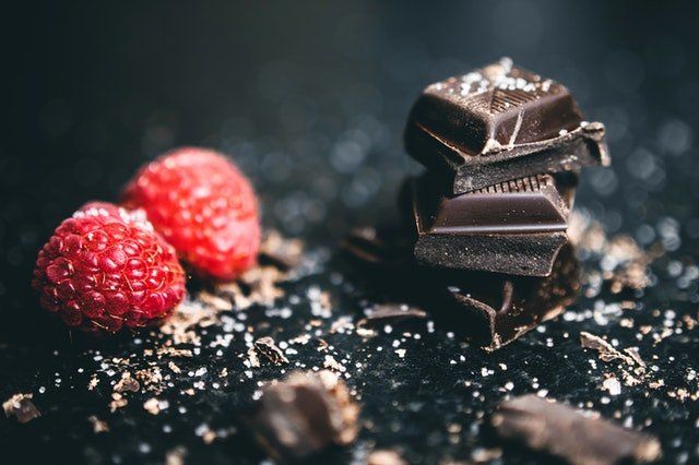Acercamiento a pedazos de chocolate y frambuesas