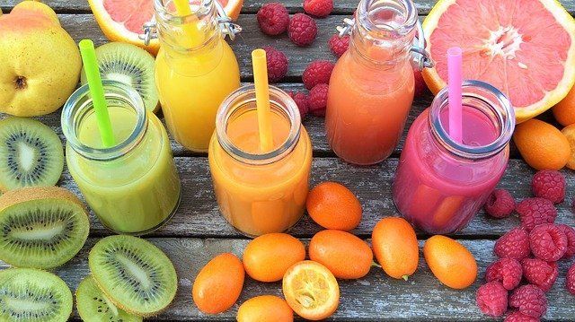 5 recipientes con jugos de fruta diferentes