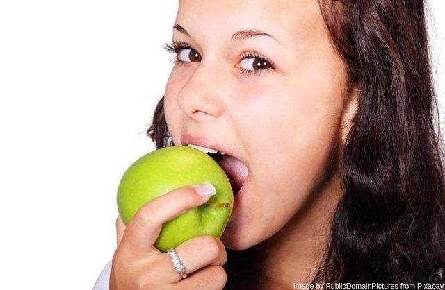 Cara de mujer mordiendo una manzana