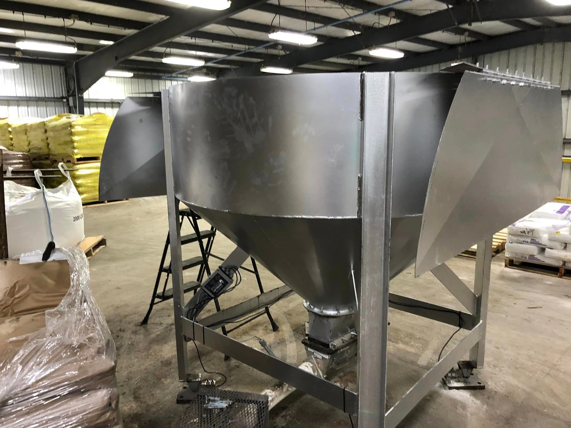 A large stainless steel container is sitting in a warehouse.