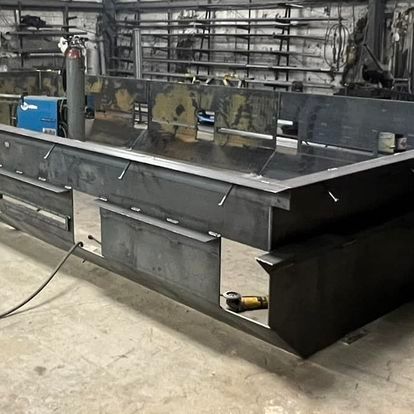 A large metal structure is being built in a factory.