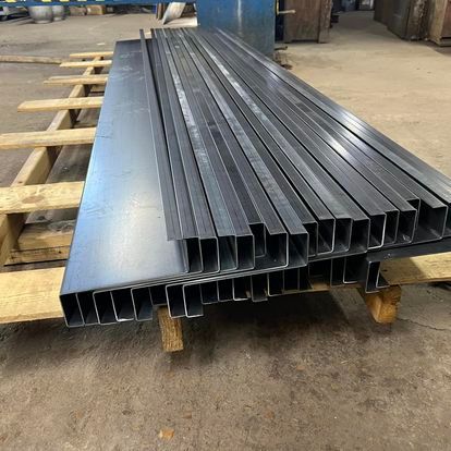 A stack of metal pipes sitting on top of a wooden pallet.