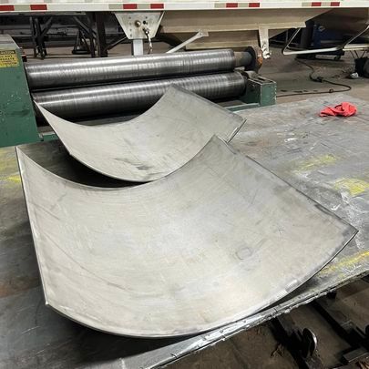 A piece of metal is sitting on top of a table next to a machine.