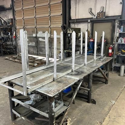 A large metal table is sitting in a garage next to an exit sign.