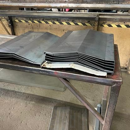 A bunch of metal pieces are sitting on top of a wooden table.