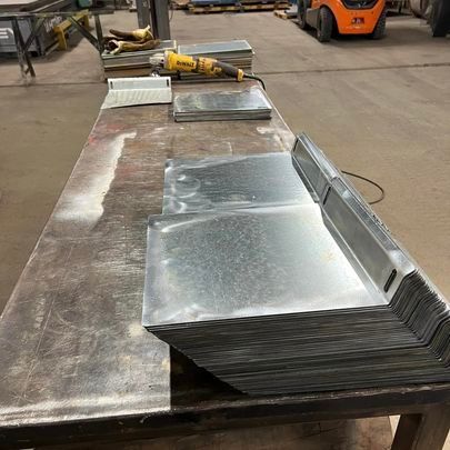 A metal table with a grinder on it in a factory.