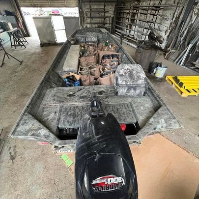 A boat with a motor is sitting in a garage.