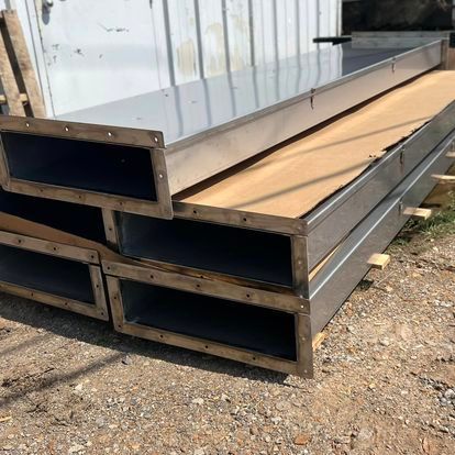 A stack of metal pipes sitting on top of each other on the ground.