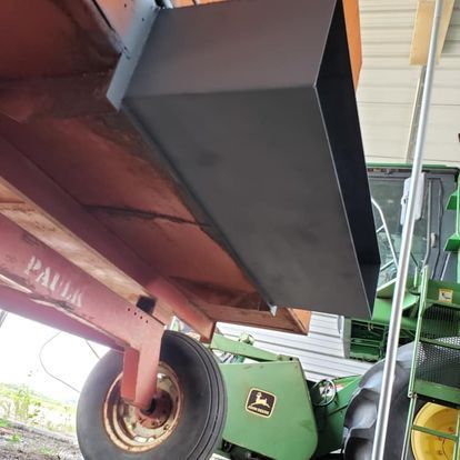 A green john deere tractor with a trailer attached to it