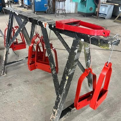 A wooden table with red pieces of metal hanging from it.
