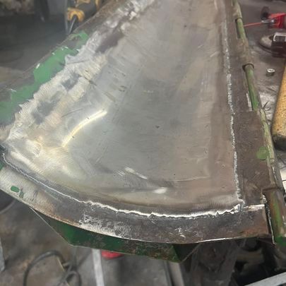 A piece of metal is sitting on top of a table in a garage.