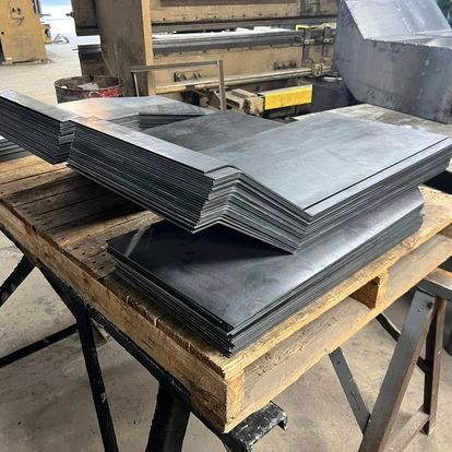 A stack of metal sheets sitting on top of a wooden table.