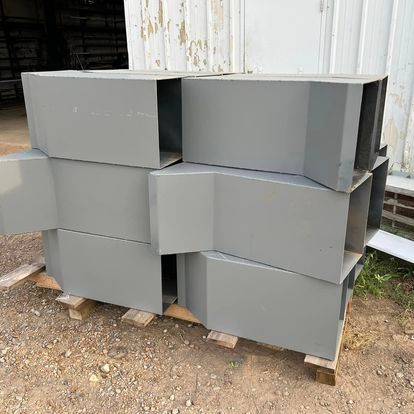 A stack of metal boxes sitting on top of each other on a wooden pallet.
